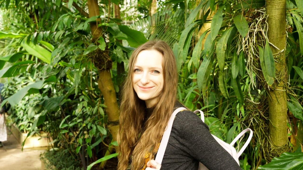 Carmen standing in front of leafy plants